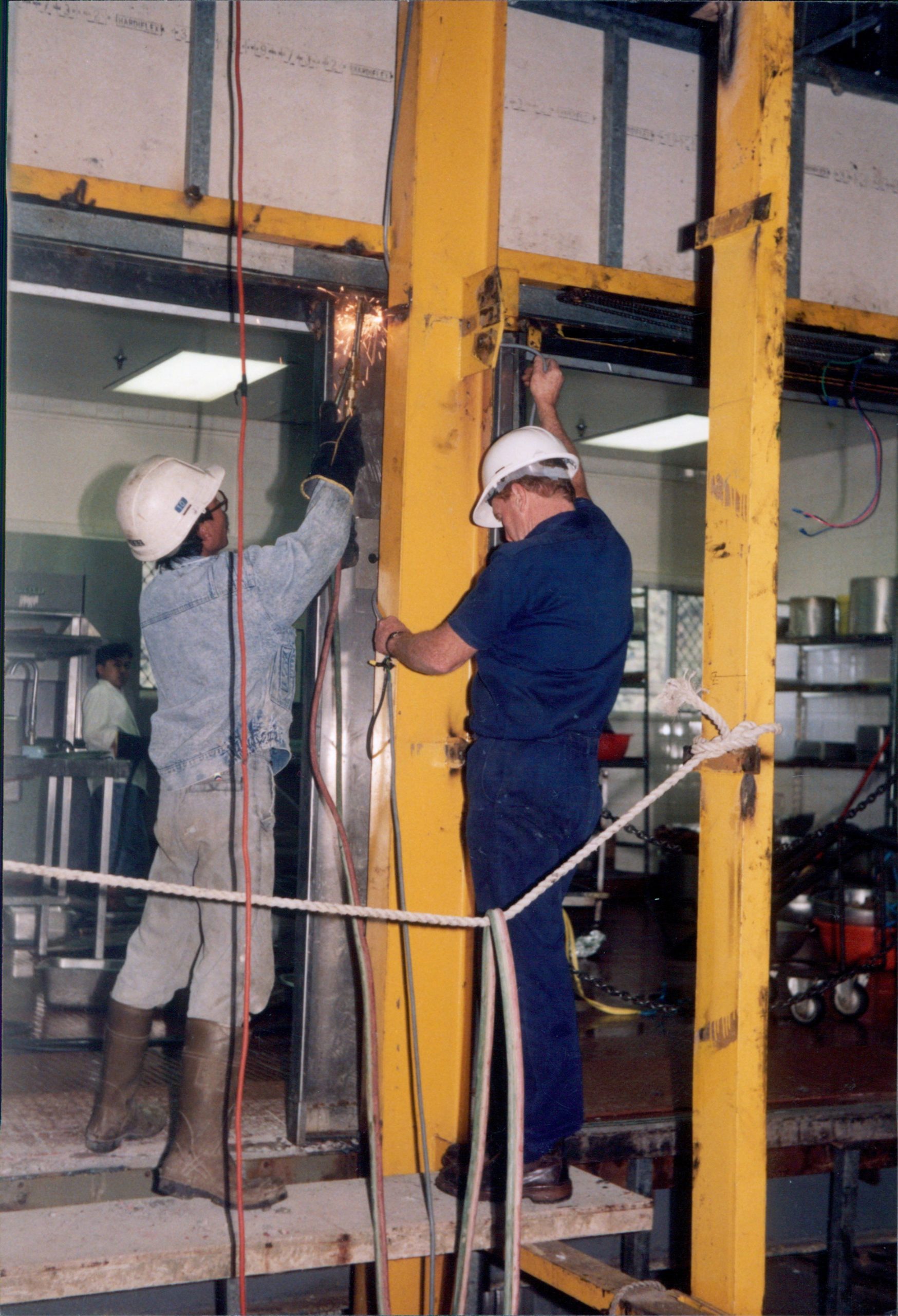 Two workers welding a metal structure