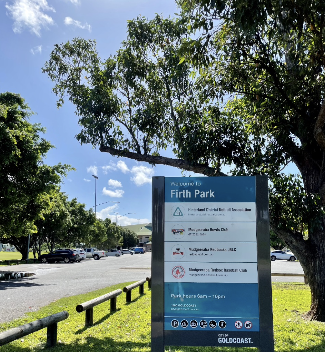 A blue sign on grass reading "Welcome to Firth Park" and displaying information