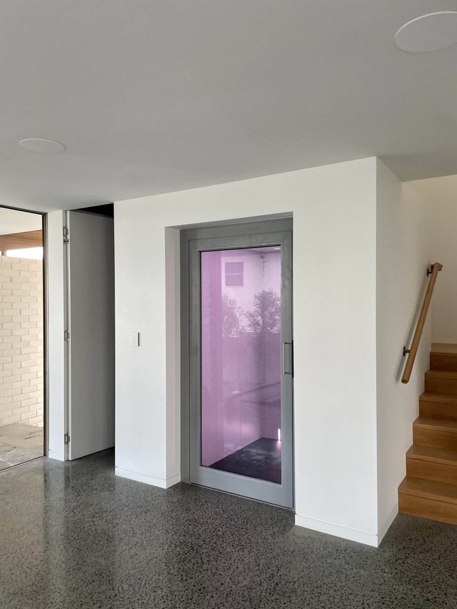 A modern home lift with purple interior light