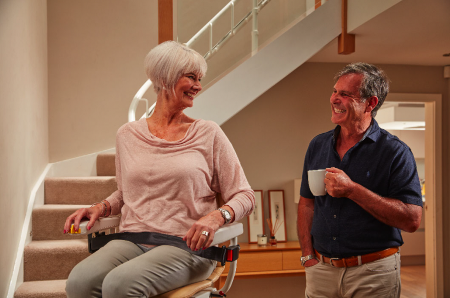 A man standing next to a woman on a stair lift