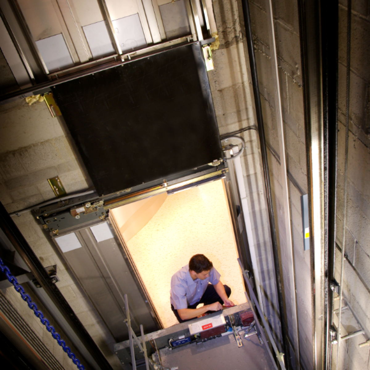 Aerial view of elevator technician fixing a lift Maintenance | Simplex Elevators Gallery Image 5